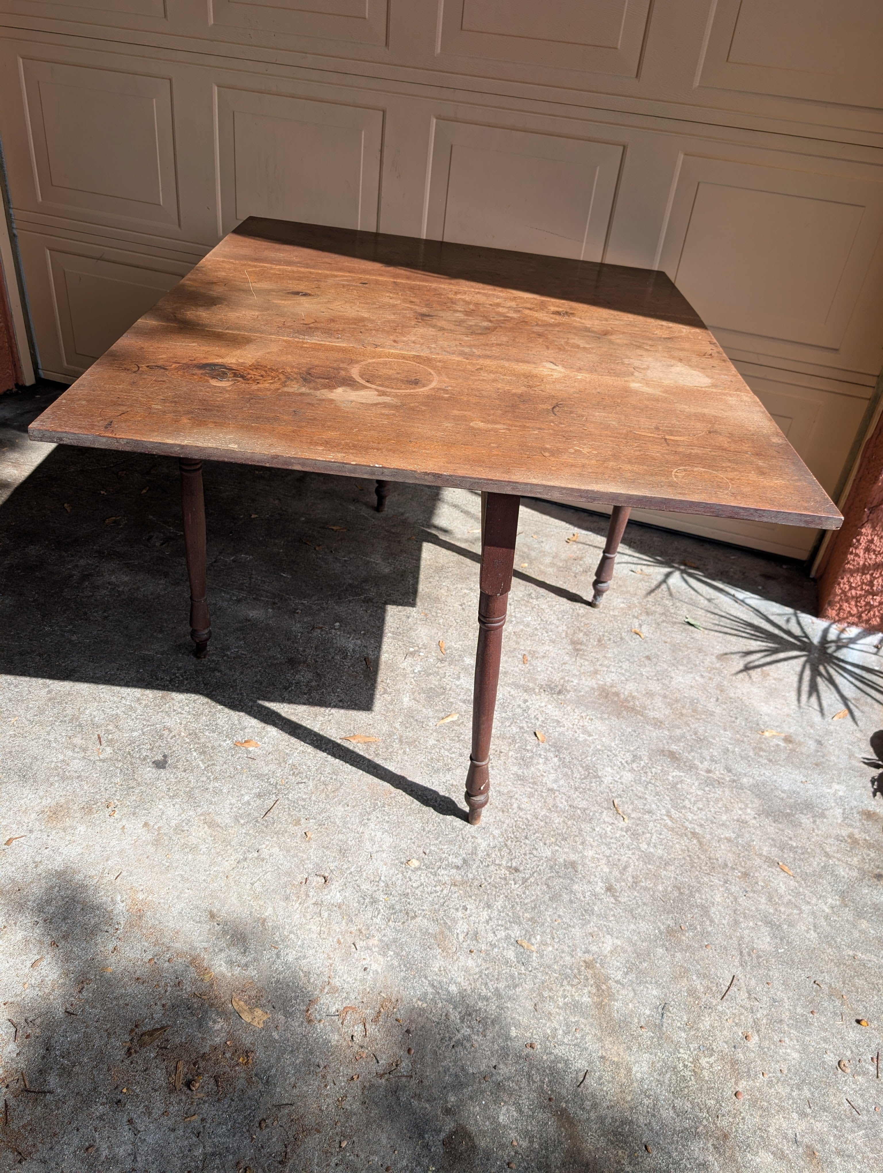 Antique wooden dining table with folding leaves