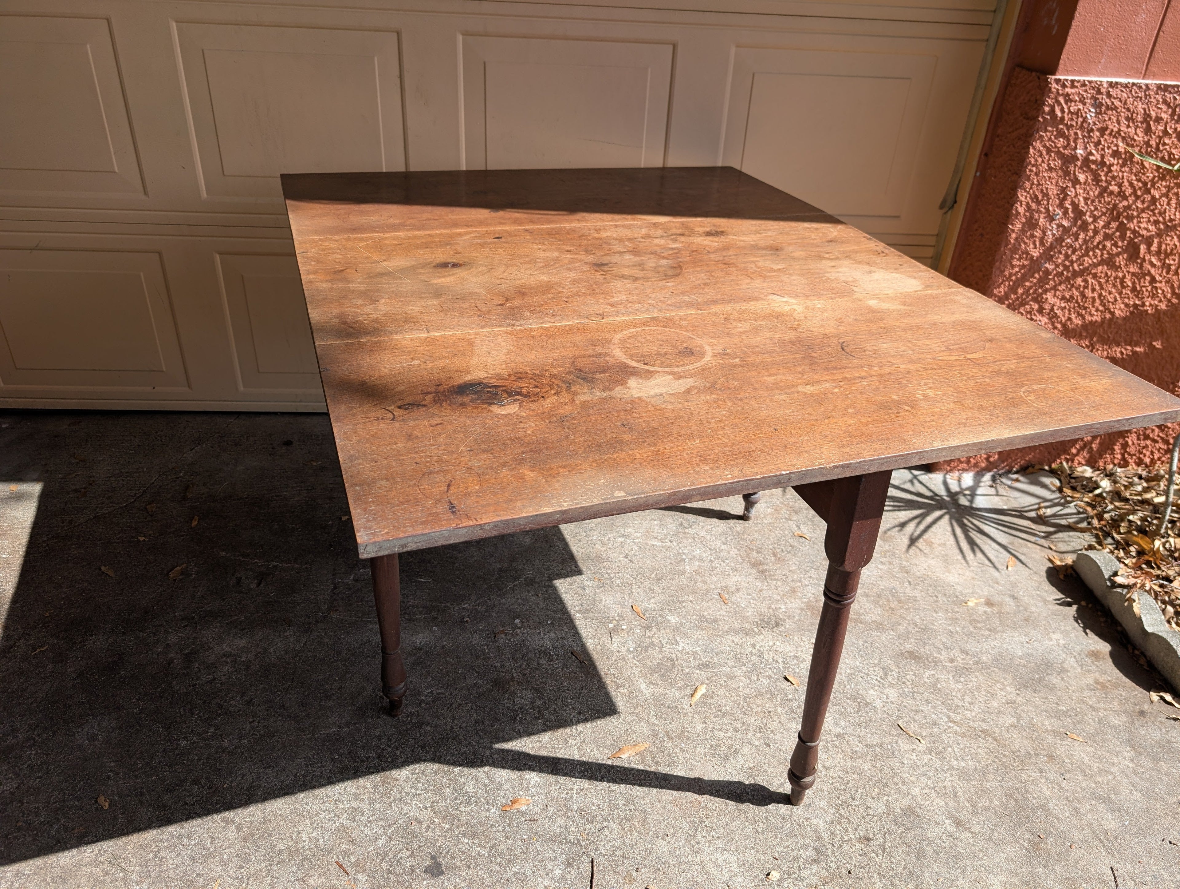Antique wooden dining table with folding leaves