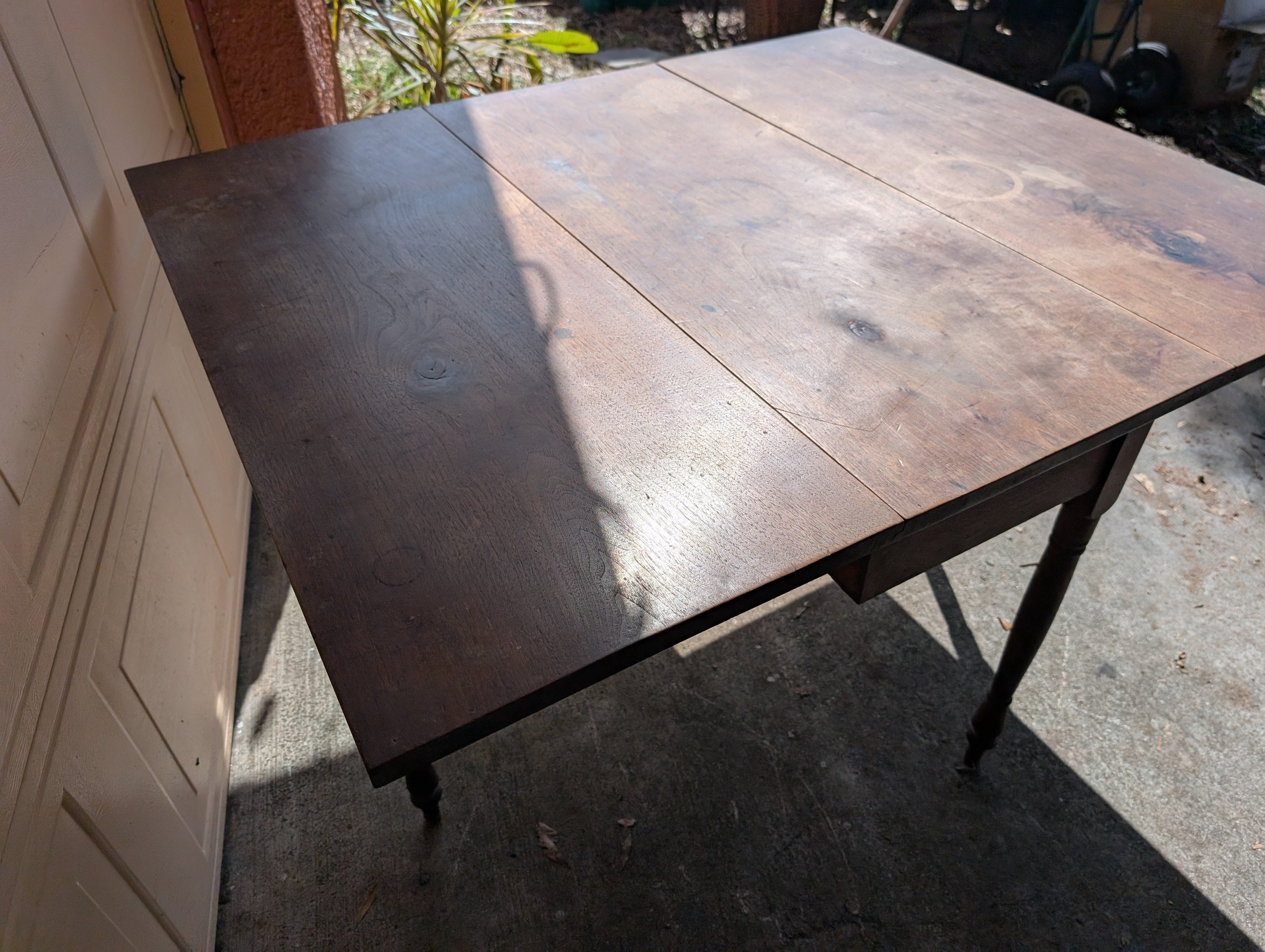 Antique wooden dining table with folding leaves
